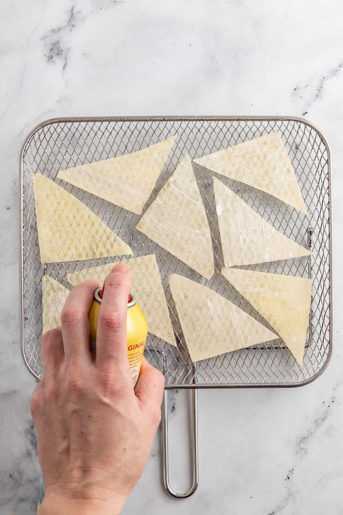 spraying wonton trianges on a rack