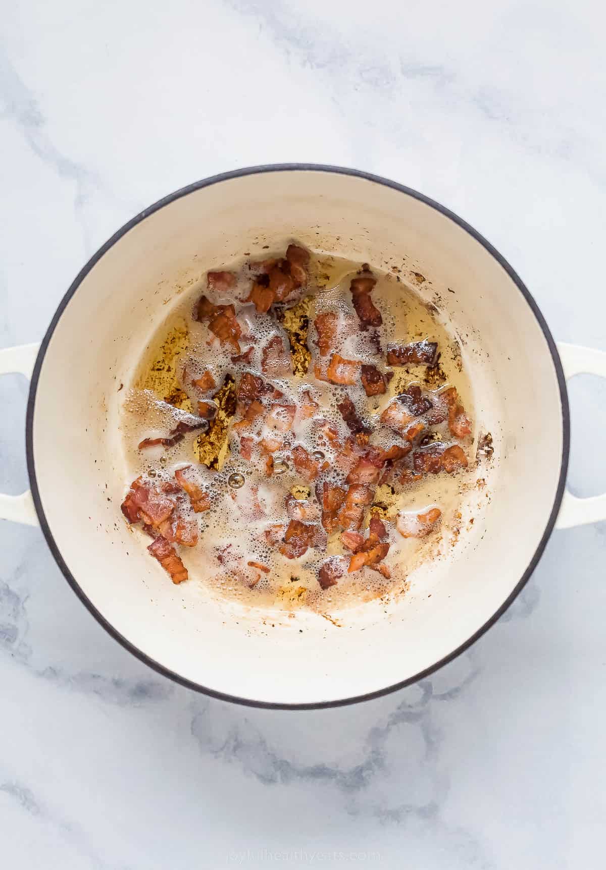 cooking cut up bacon in a large dutch oven