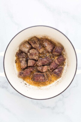 searing peices of beef in a large pot