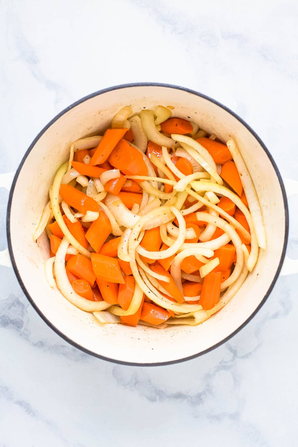 chopped carrots and sliced onions in a dutch oven