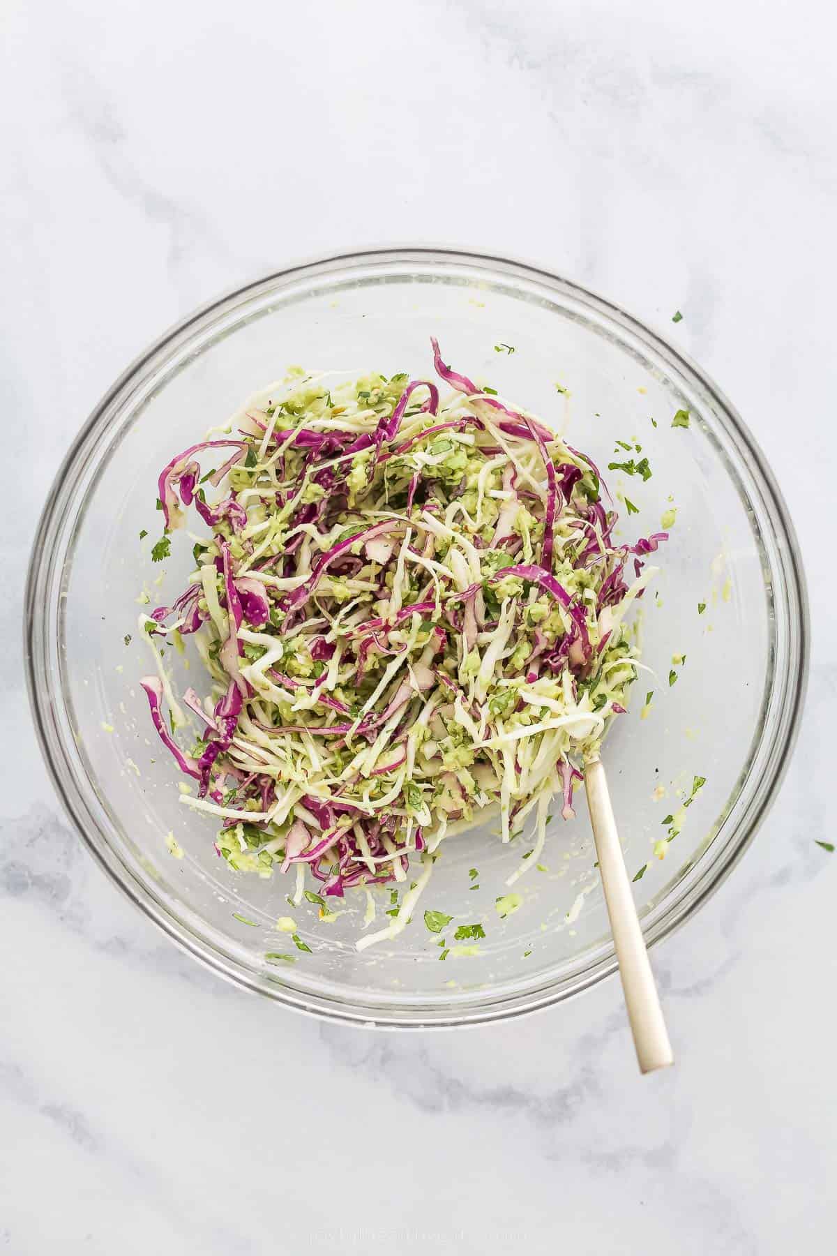 mixing shredded coleslaw in a bowl