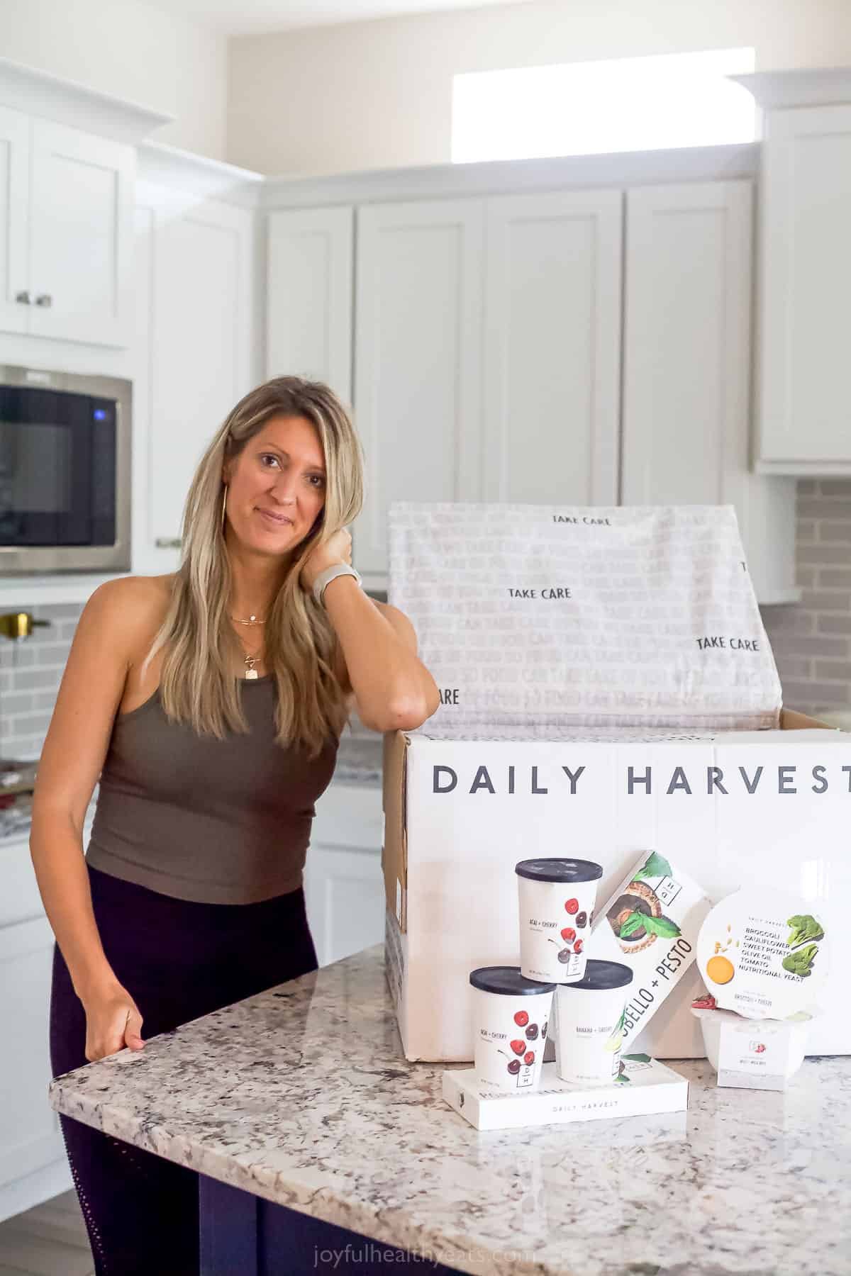 girl leaning up against a daily harvest box