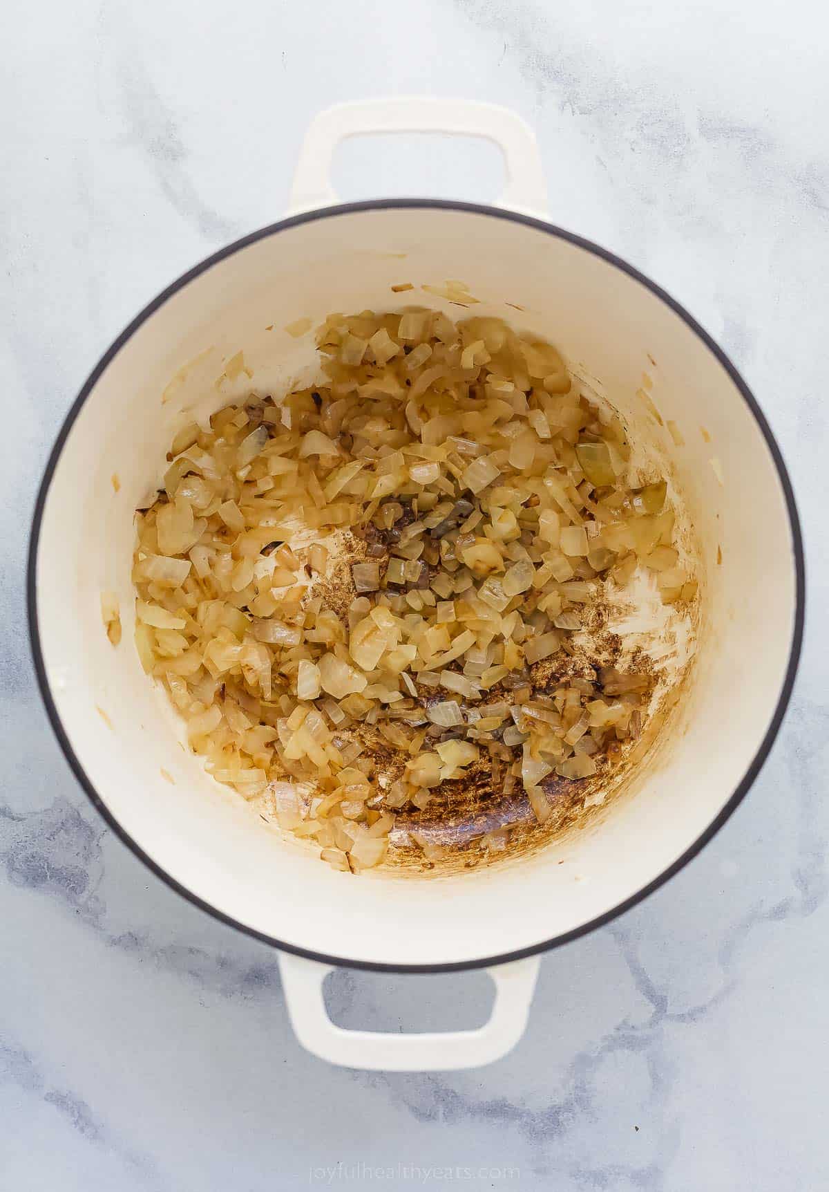 cooking onions and garlic in a large pot with almonds