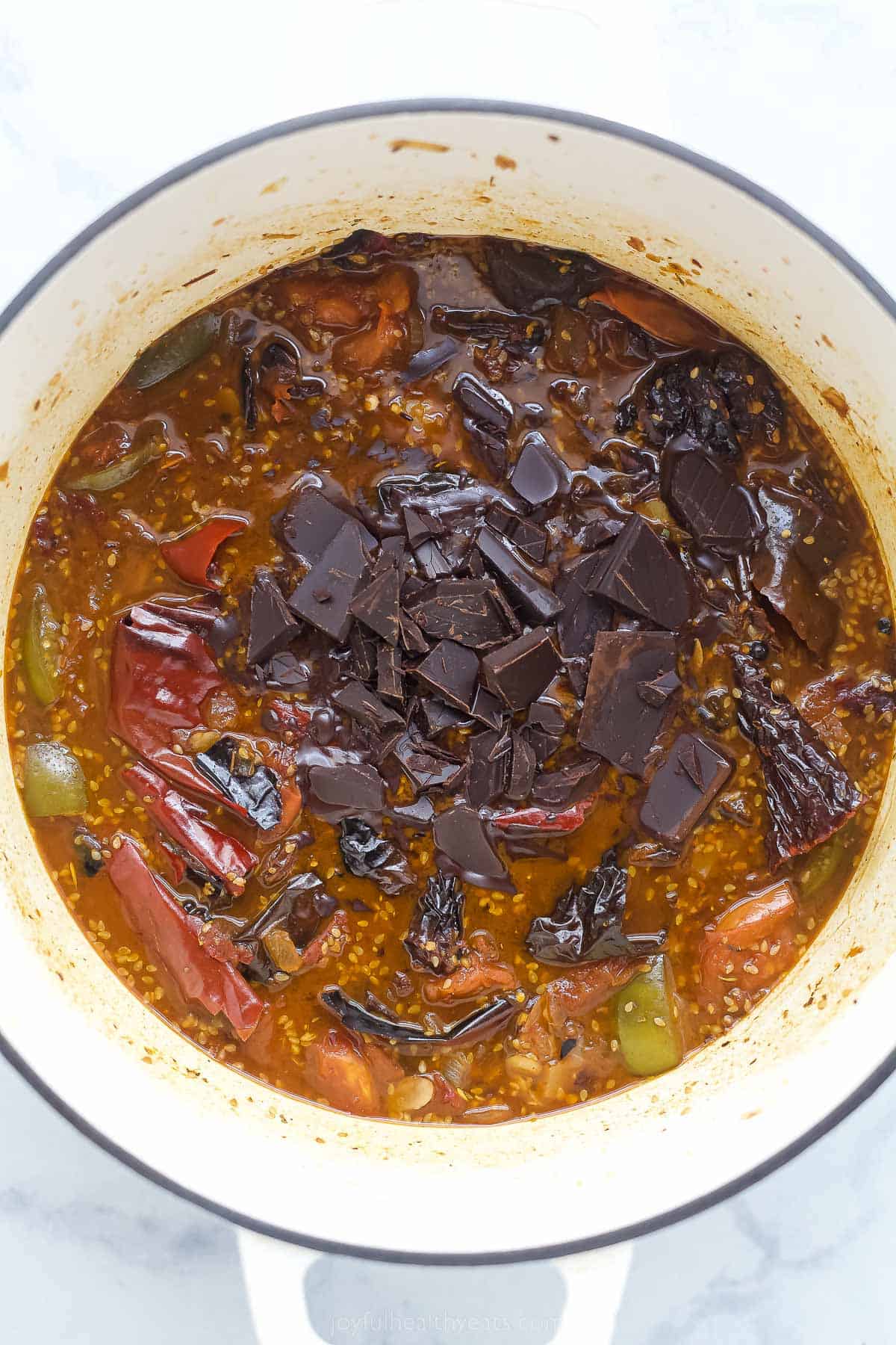 a dark colored base sauce with dried chilies, tomatoes, and spices