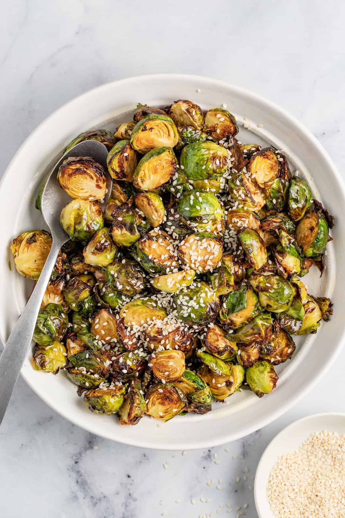 a bowl of crispy brussels sprouts with a spoon