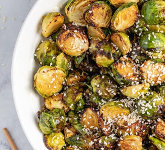 a bowl of asian-inspired brussels sprouts with sesame seed garnish