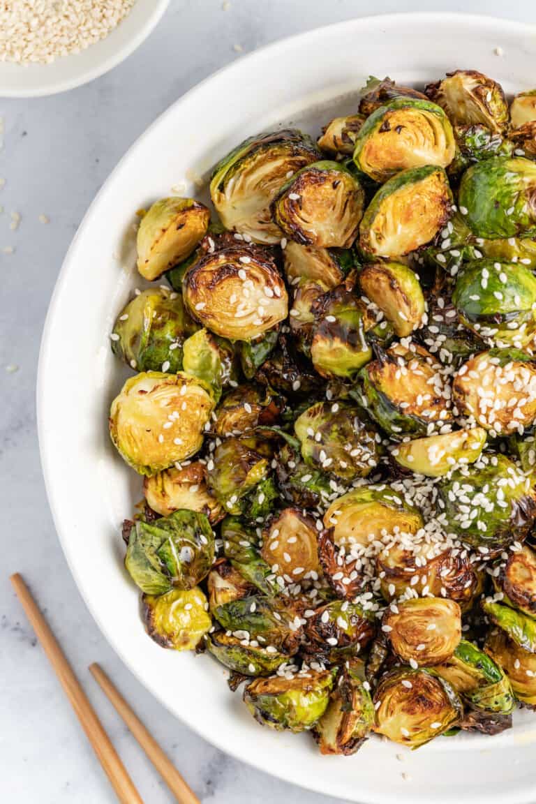 a bowl of asian-inspired brussels sprouts with sesame seed garnish