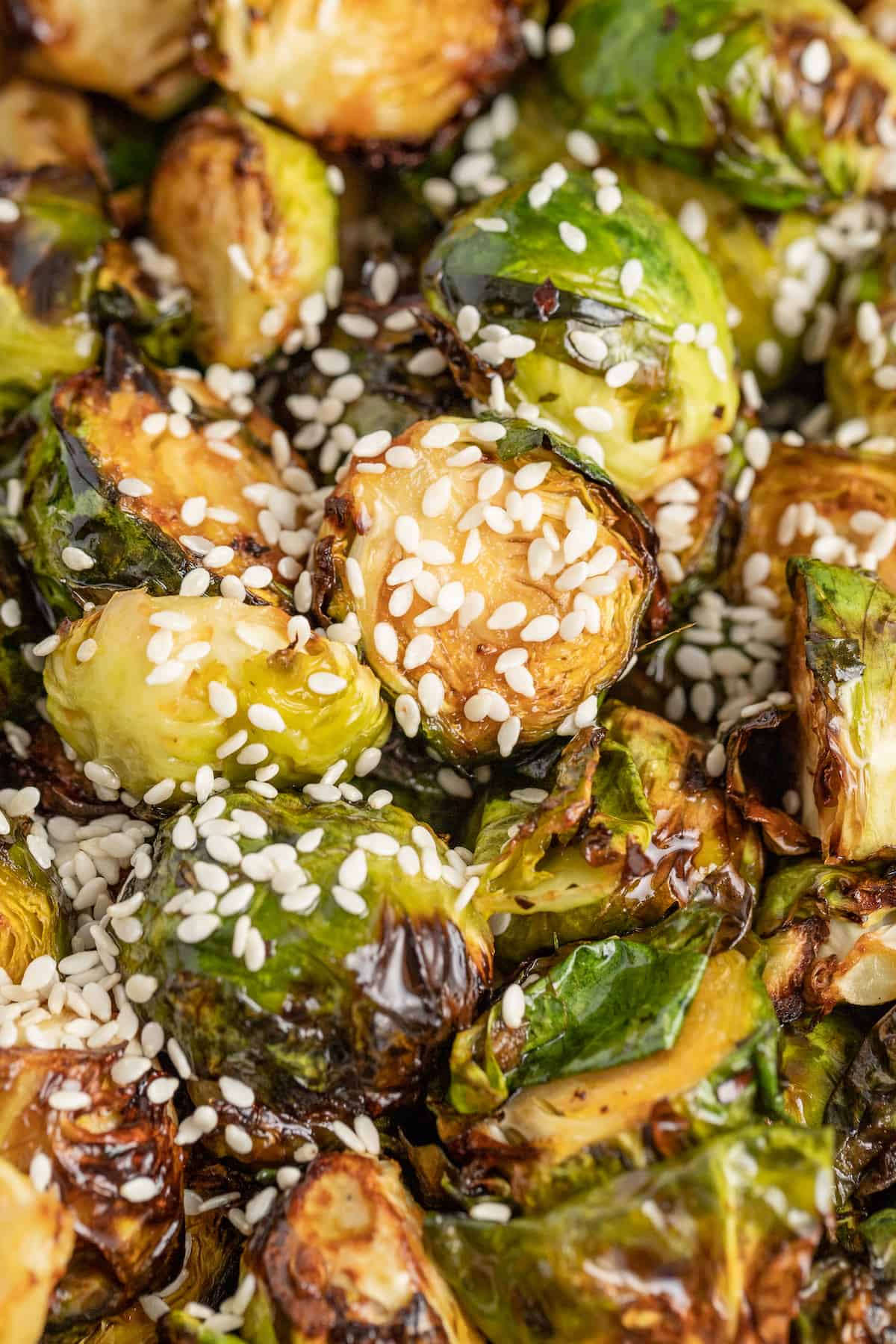 These Crispy Asian Air Fryer Brussels Sprouts are crunchy little bites filled with lots of soy, ginger, garlic, and spicy flavor. crispy asian air fryer brussels sprouts with sesame seed garnish
