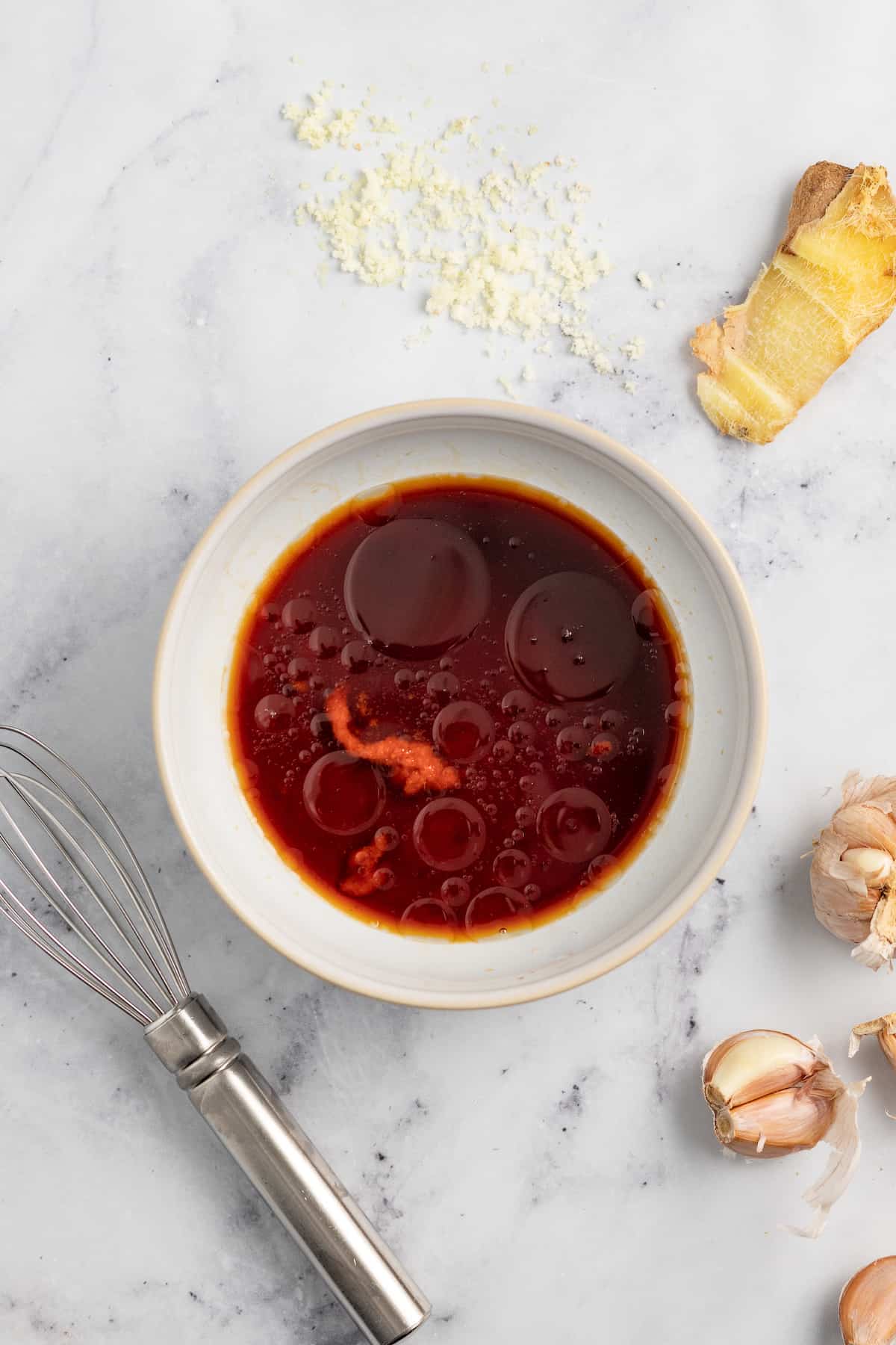 a small bowl with a red colored liquid seasoning