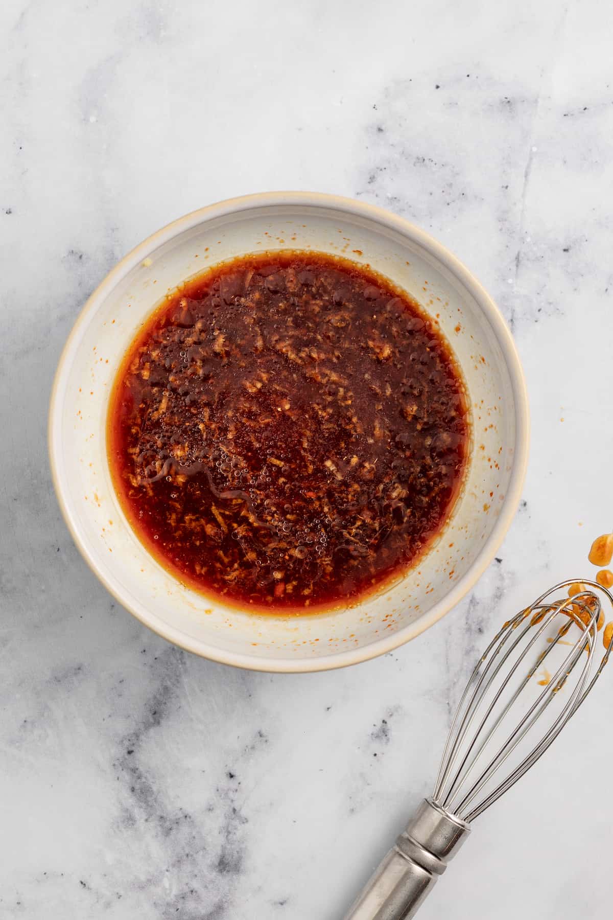 a small bowl with a red colored liquid seasoning