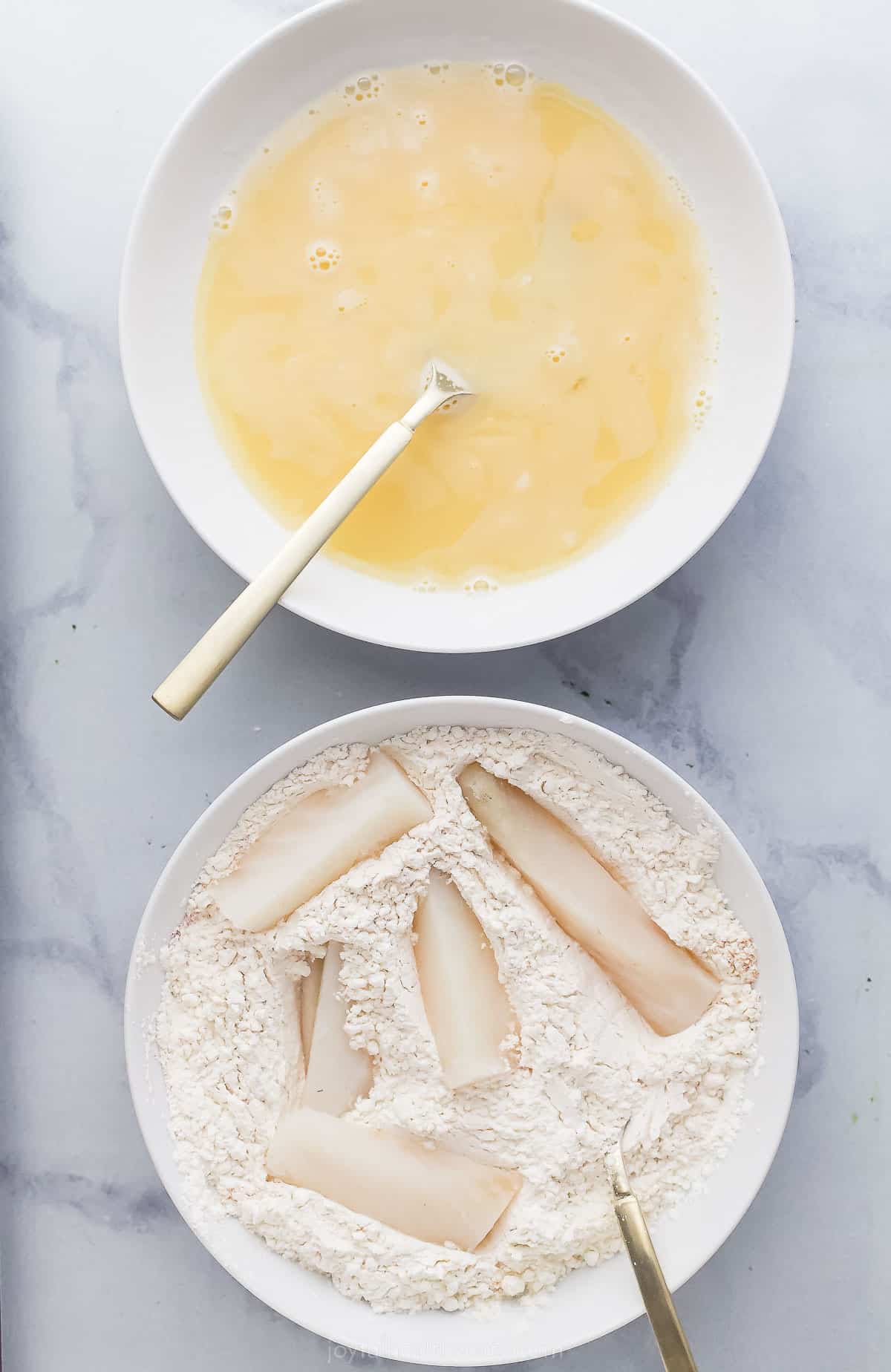 fish sticks in a bowl with a dry mixture and another bowl of batter next to it