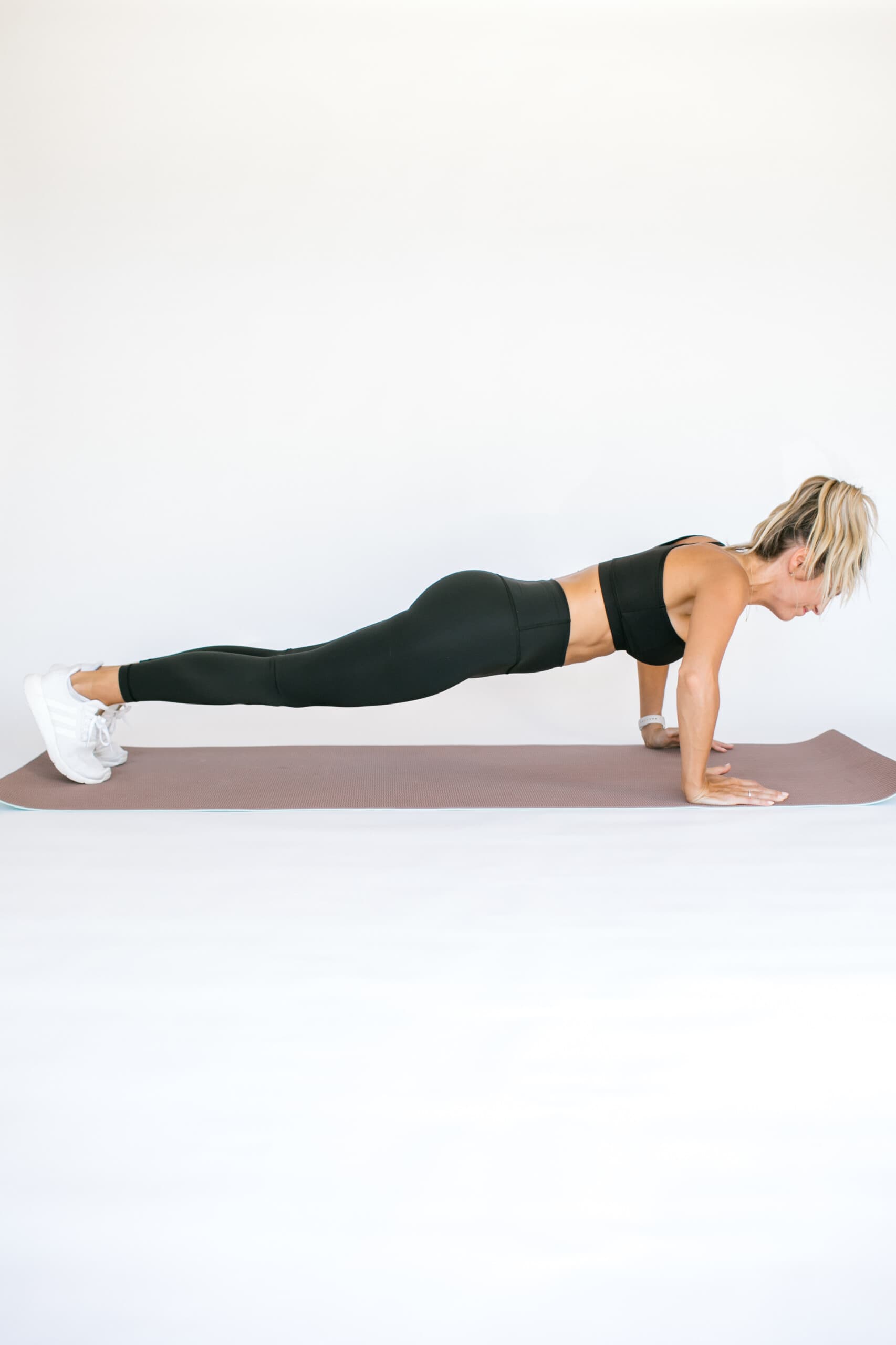 girl in plank position lowering down down to pushup