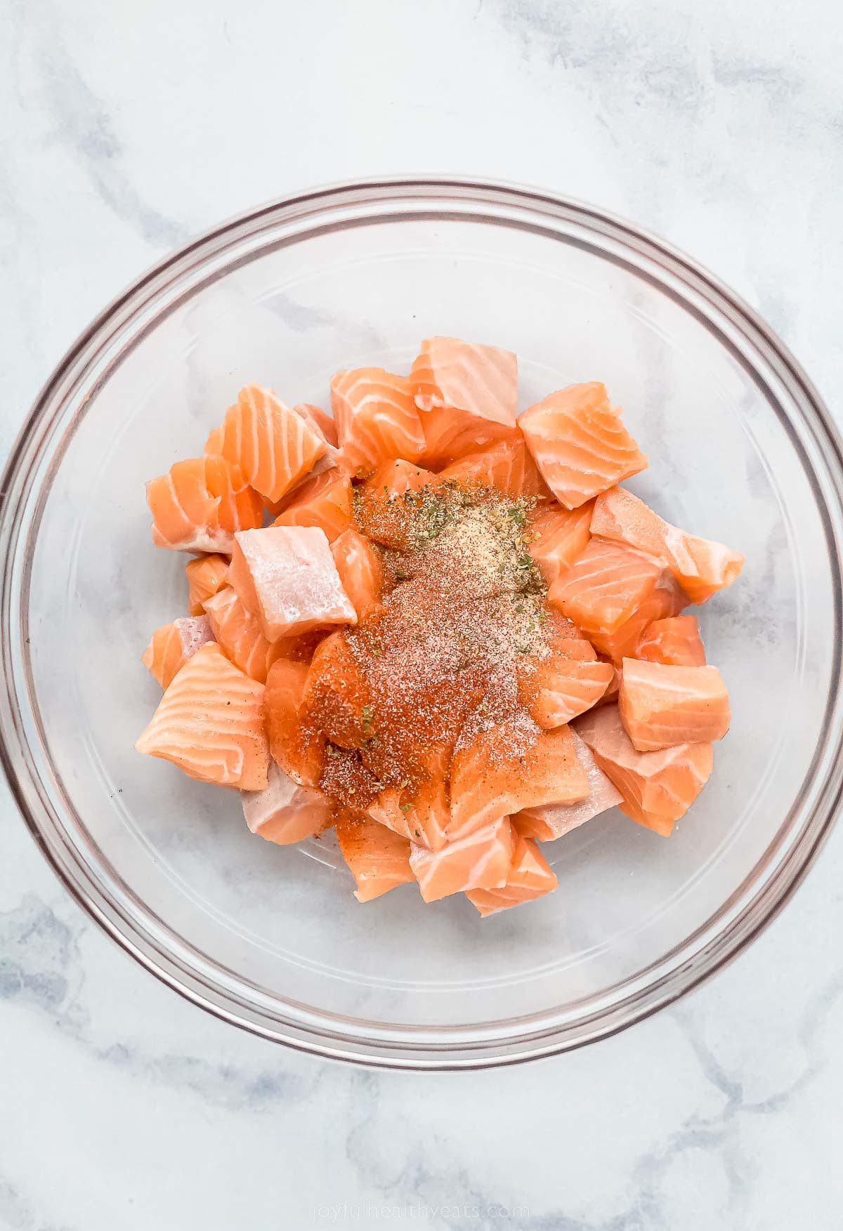 Adding the seasoning to the diced salmon. 