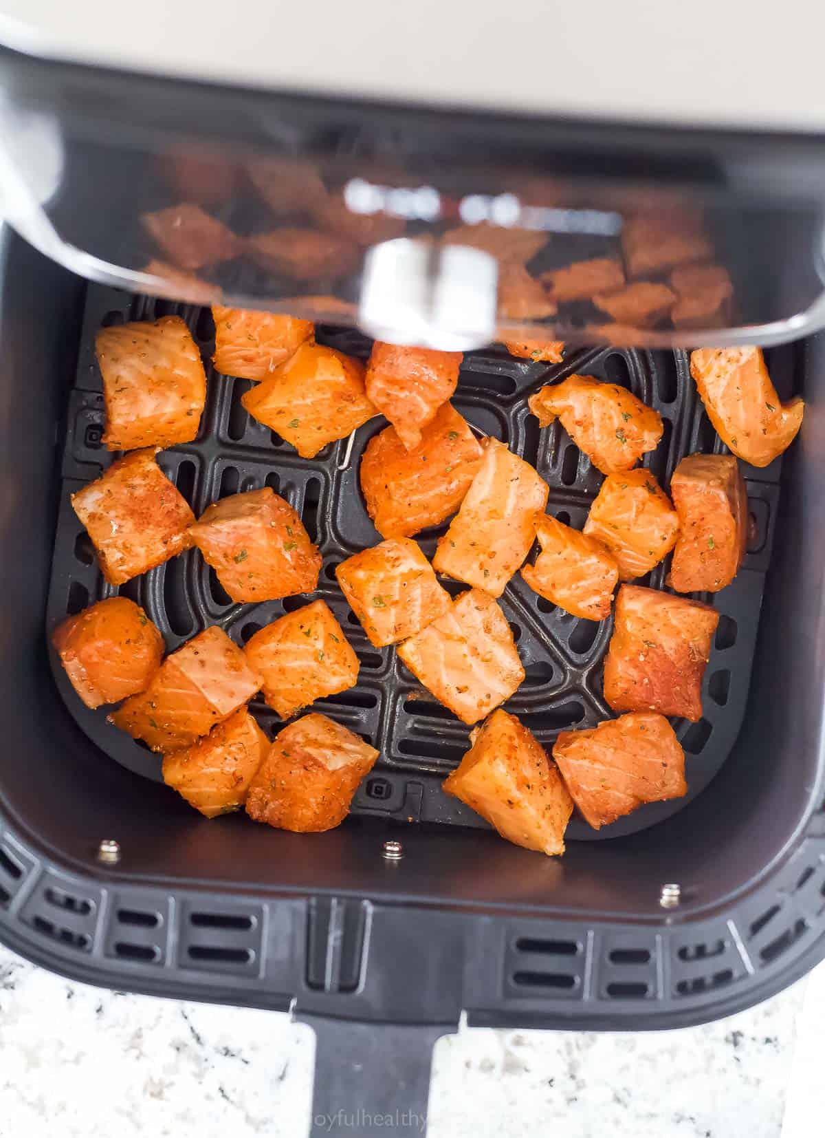 Arranging the salmon in the air fryer basket. 