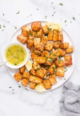 Overhead shot of air fryer salmon bites with honey butter on the side.
