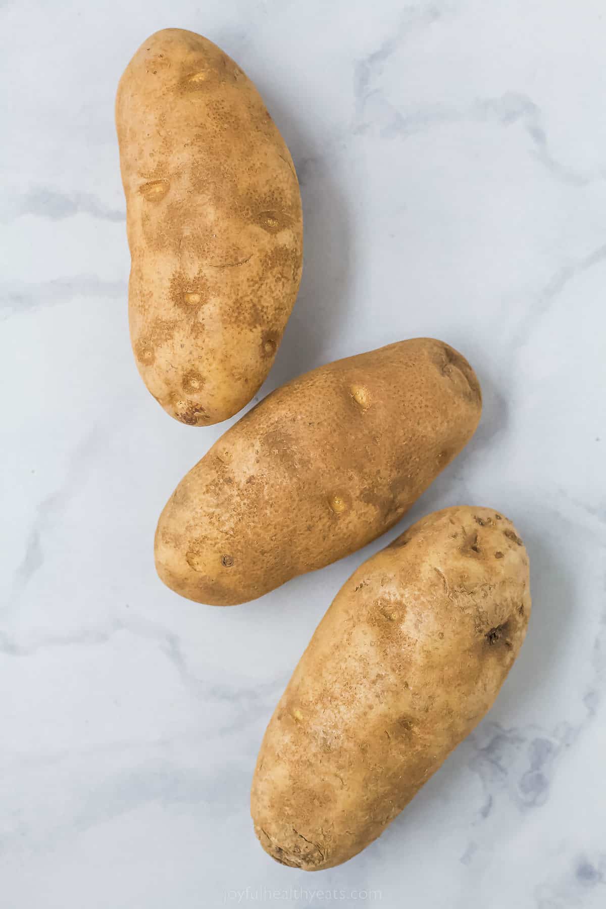 Three russet potatoes for pommes frites. 