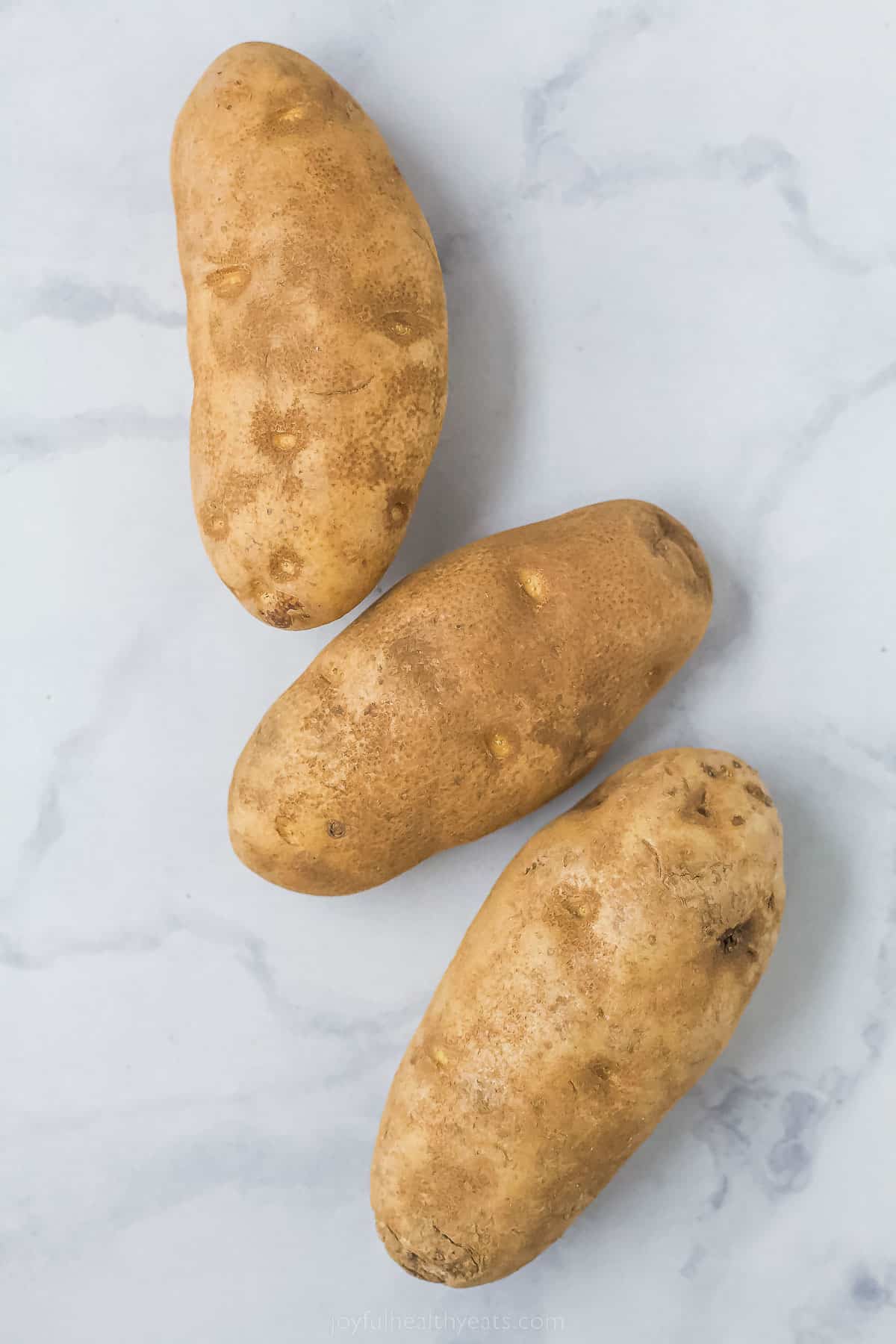 Three russet ،atoes for pommes frites. 