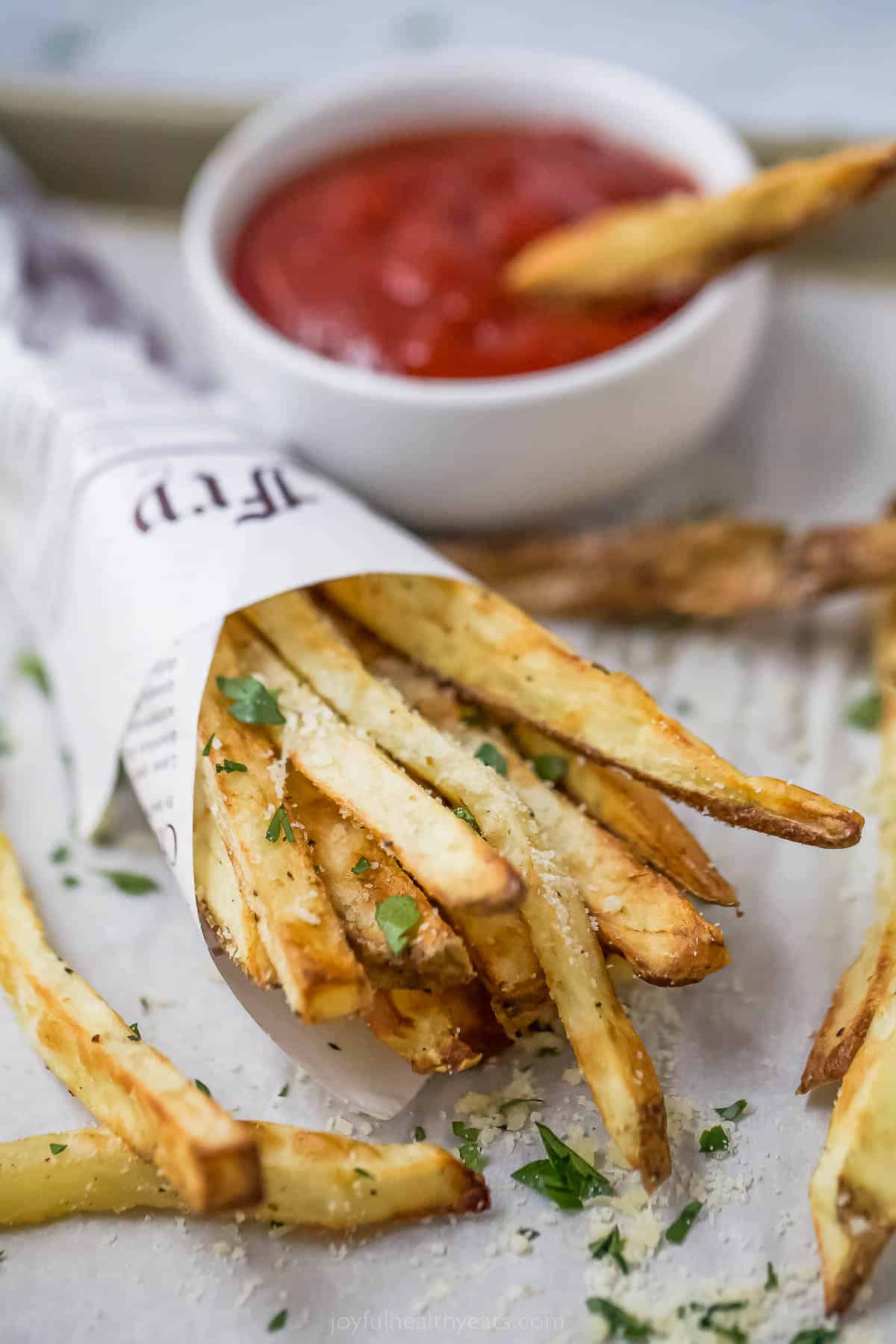 Close-up of pommes frites with ketchup in the background. 