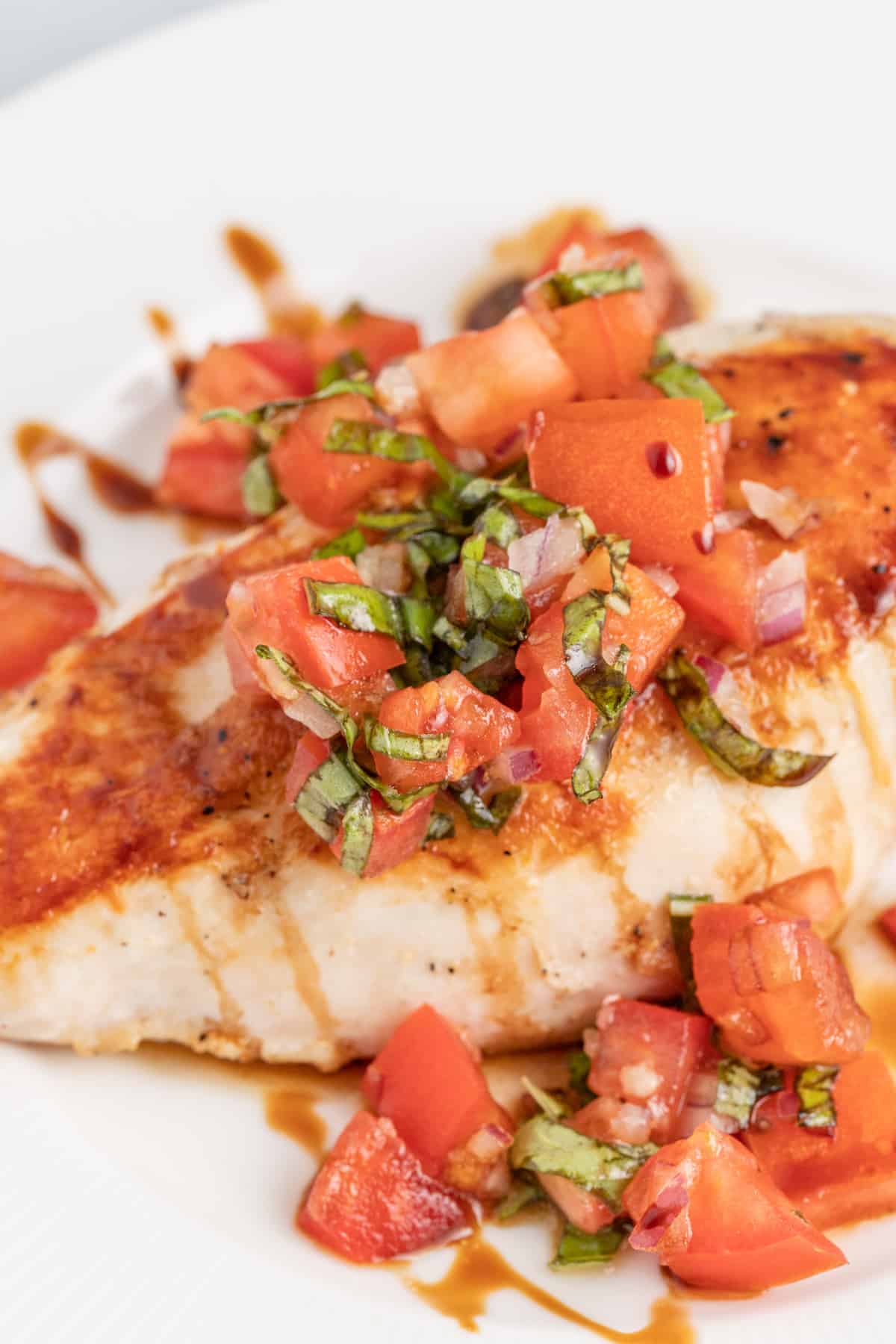 This juicy chicken bruschetta with an Italian-inspired summer veggie topping is the perfect 20-minute healthy but flavorful work lunch. Close-up of chicken bruschetta.