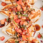 Chicken bruschetta on a plate with a drizzle of balsamic reduction.