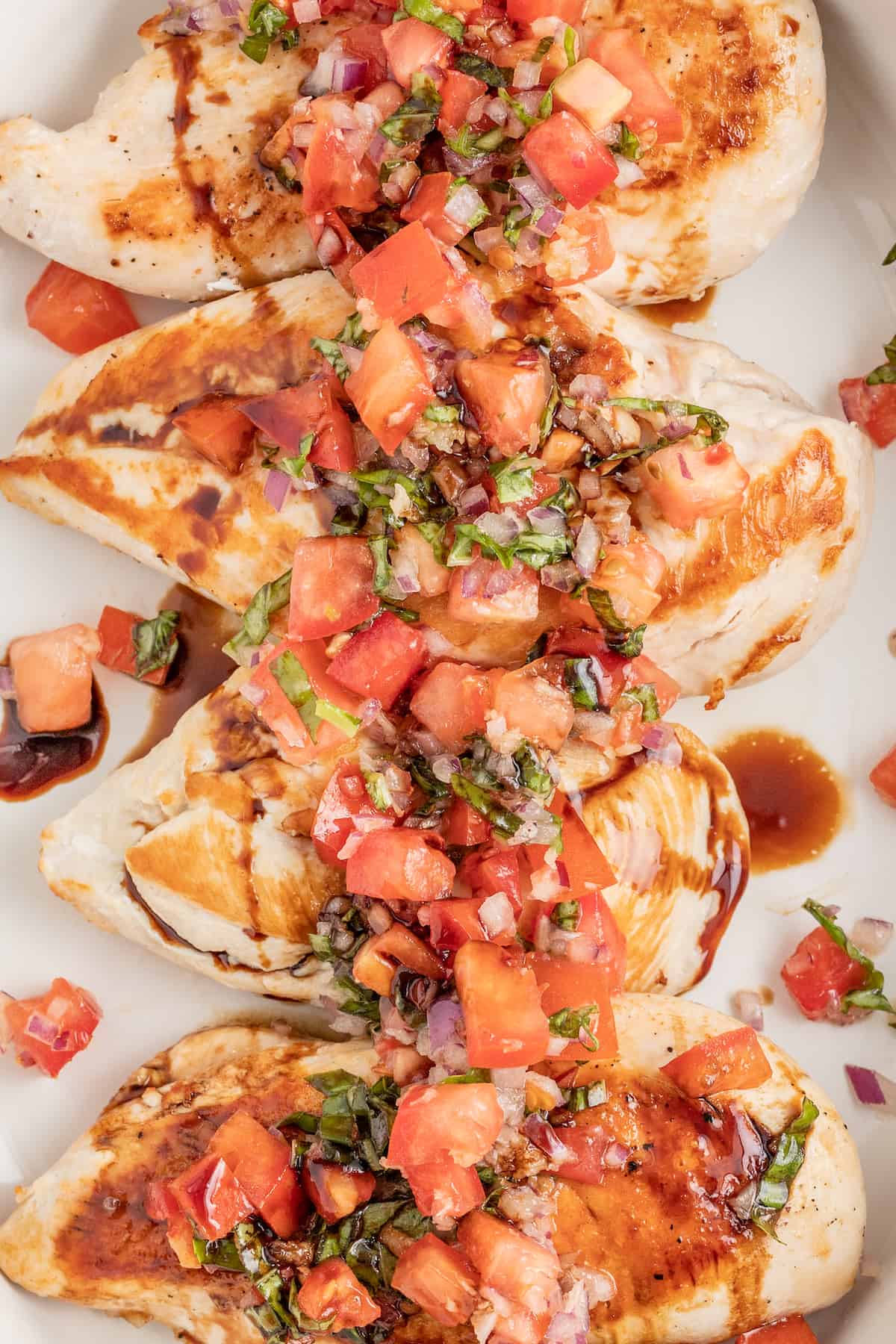 Chicken bruschetta on a plate with a drizzle of balsamic reduction. 