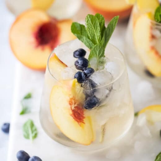 Peach sangria with mint in a crystal glass.