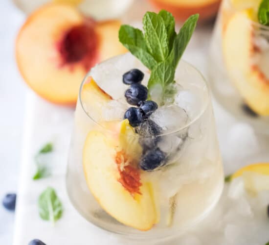 Peach sangria with mint in a crystal glass.