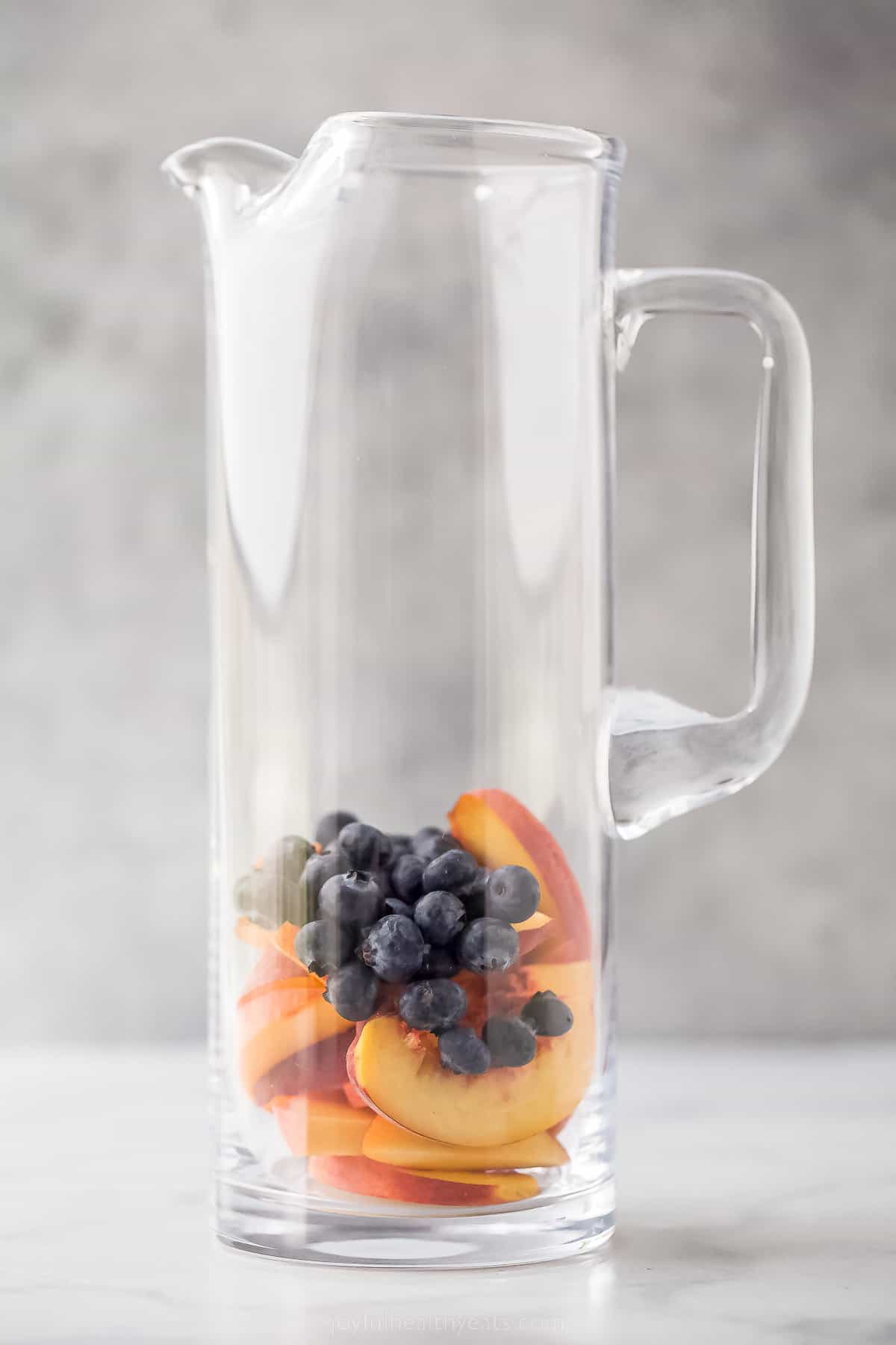 Adding the blueberries to the pitcher.