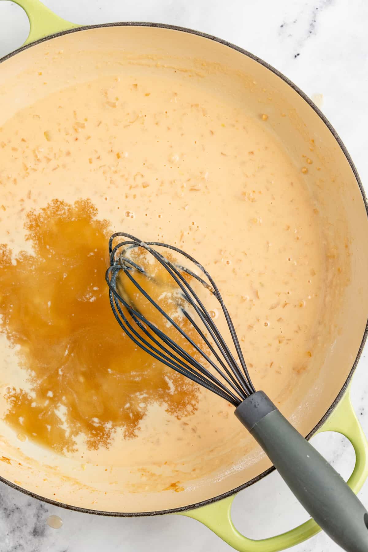 Pouring the chicken broth into the pan.