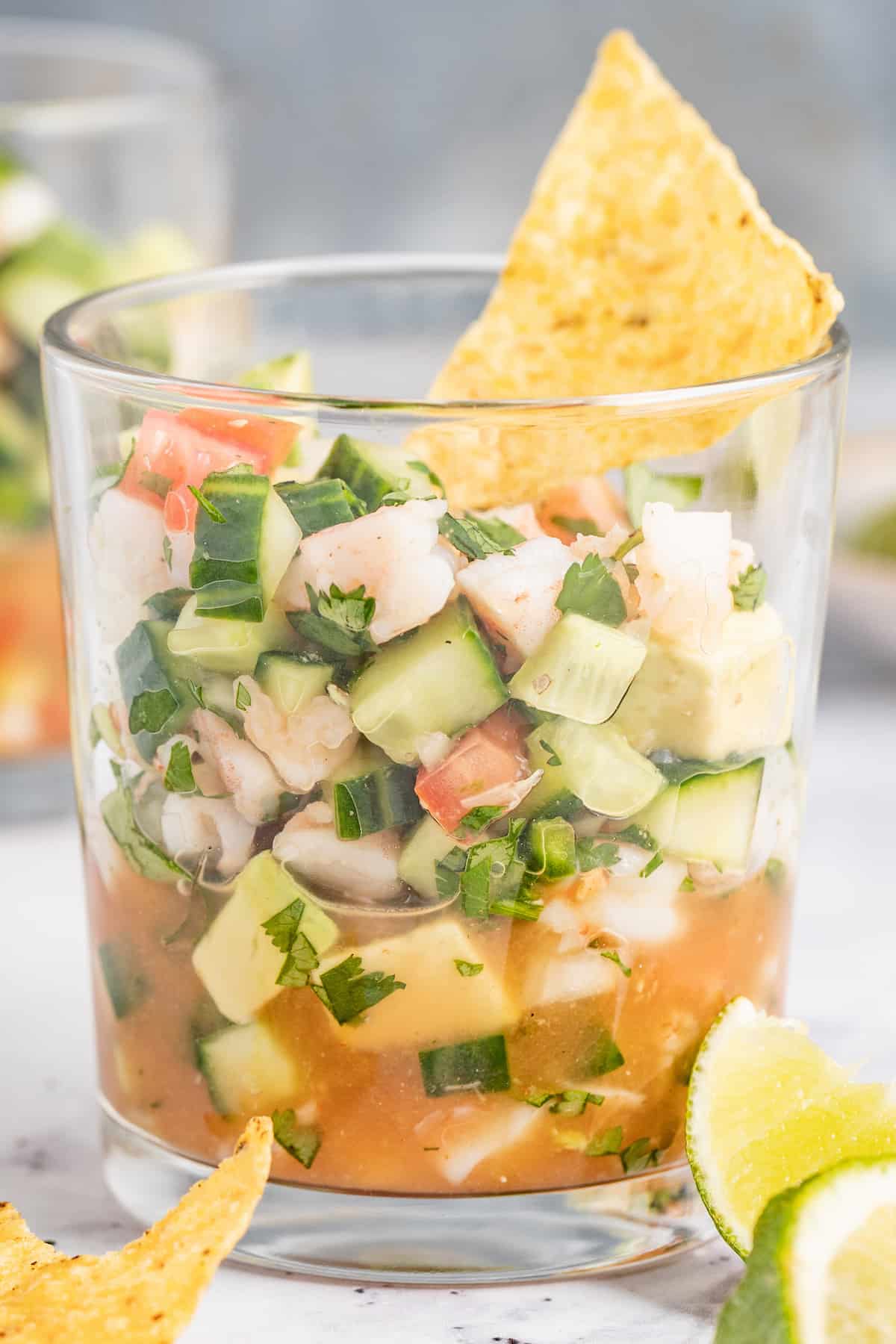 Glass of ceviche de camaron with tortilla chips. 