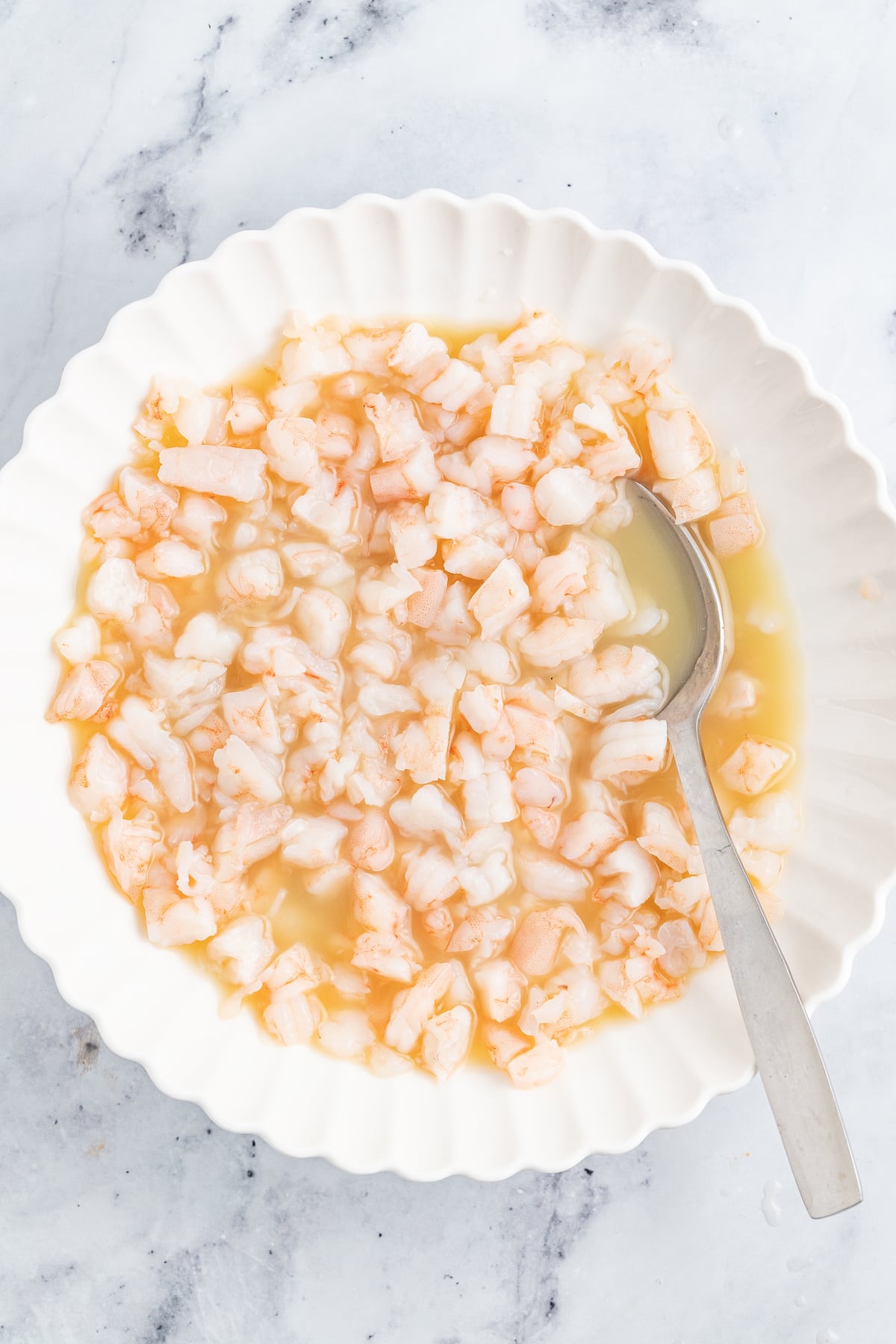 Mixing the lemon juice and diced shrimp. 