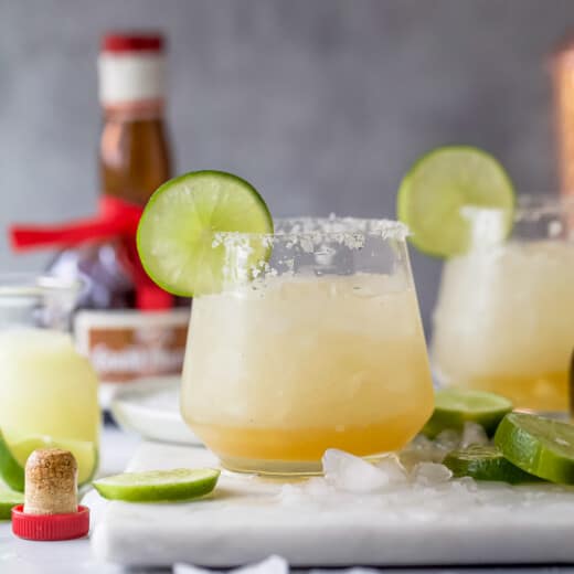 Cadillac margarita with ice and a lime wedge.