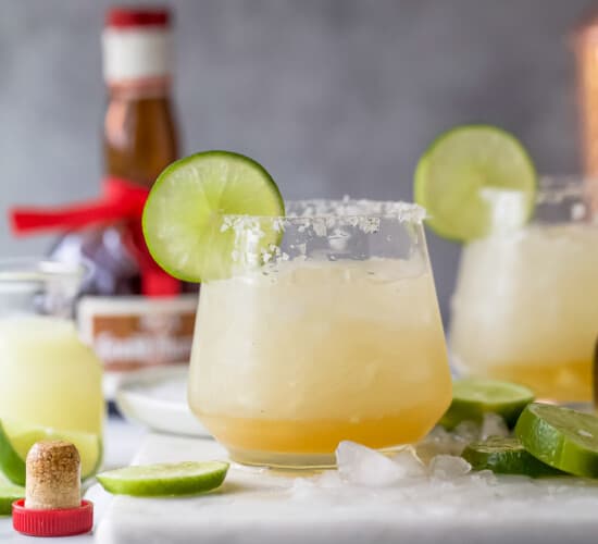 Cadillac margarita with ice and a lime wedge.