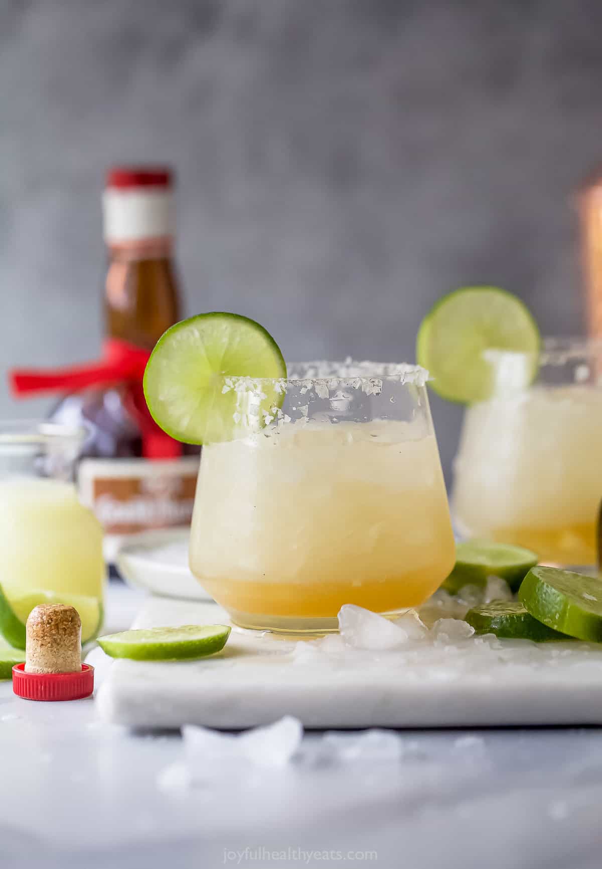 Cadillac margarita with ice and a lime wedge.