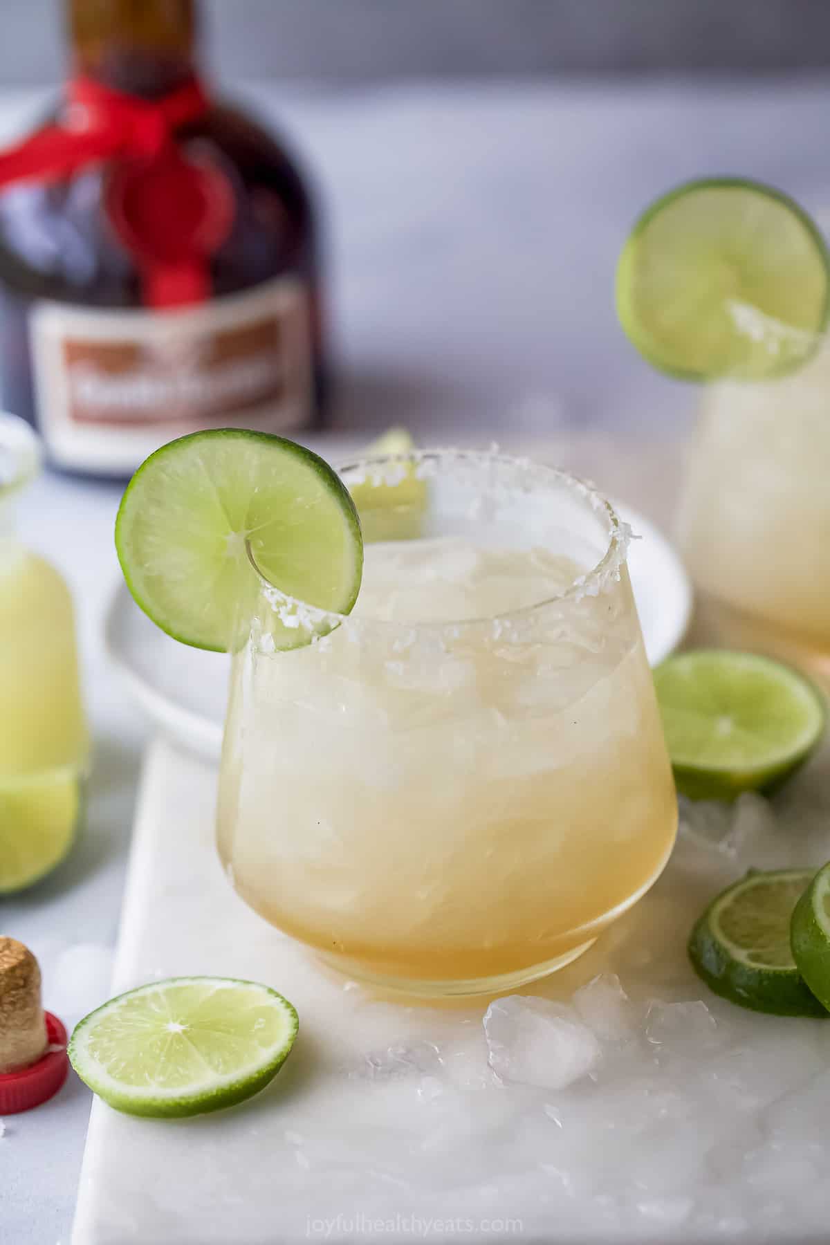 Cadillac margarita with a salt rim and a lime wedge.