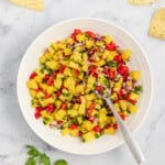 Pineapple salsa in a bowl with corn chips on the side.