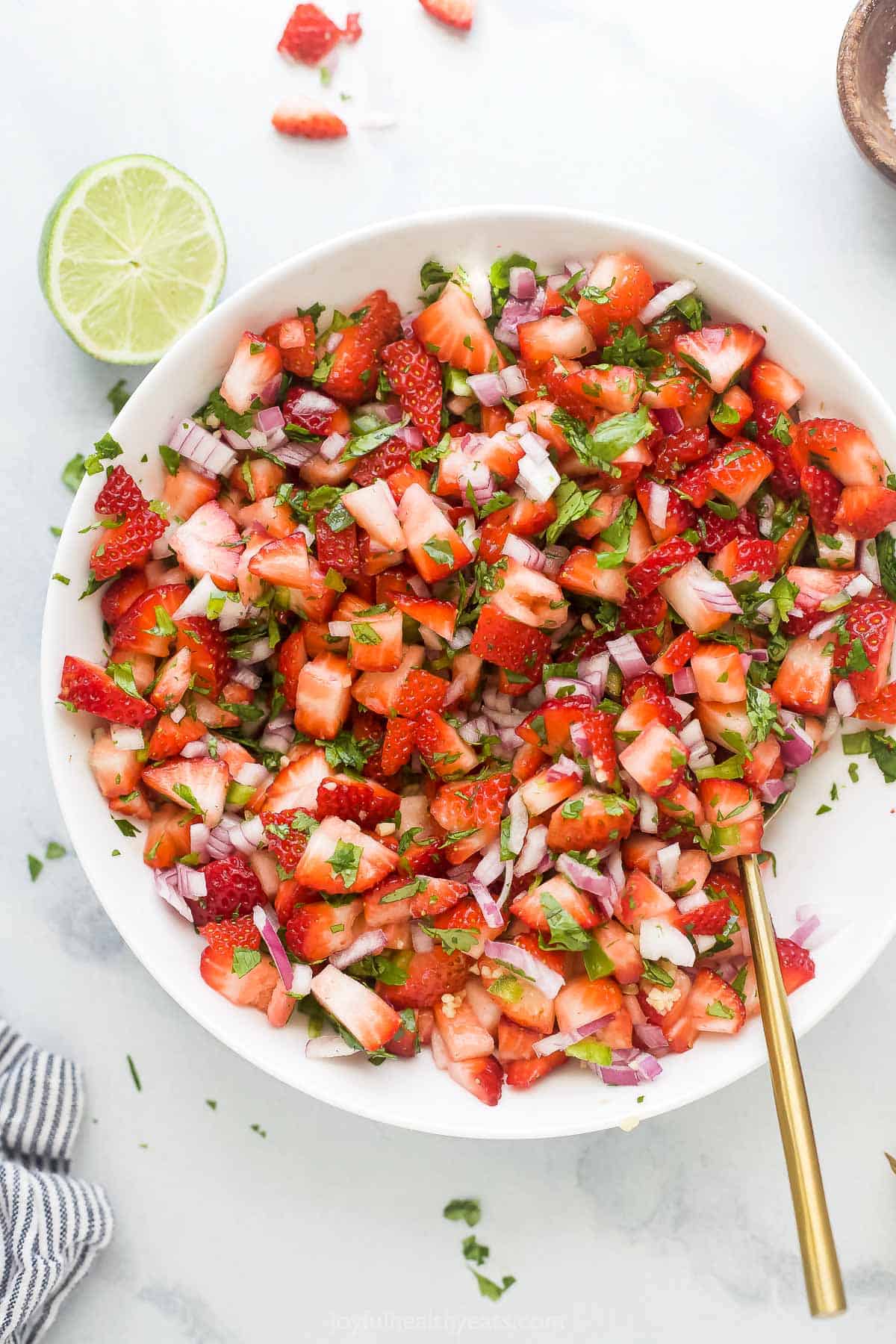This 10-minute strawberry salsa is fruity, spicy, and tangy all in one bite. It's the perfect summer appetizer with corn chips! Strawberry salsa in a bowl.