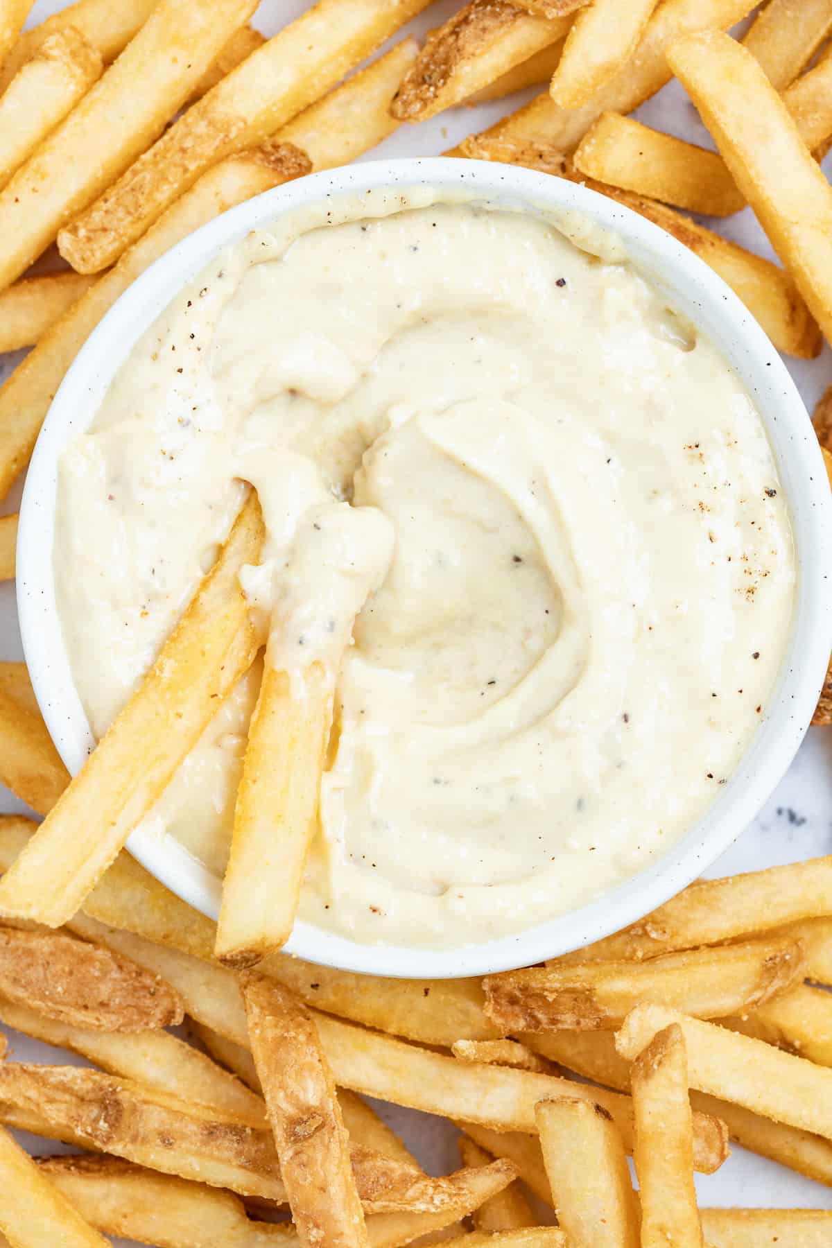 Dipping french fries into aioli. 