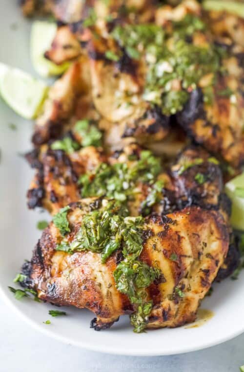 Close-up of grilled chicken with chimichurri on top.