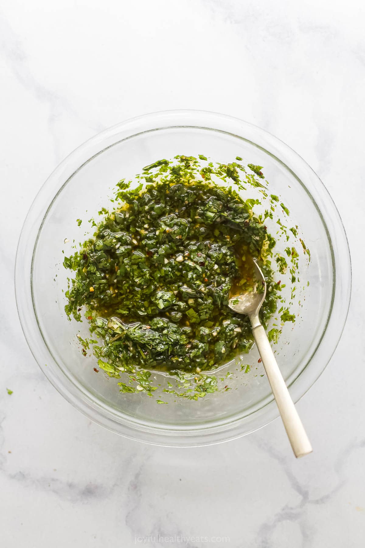 Topped with extra chimichurri, this juicy chimichurri chicken will be your new excuse to fire up the grill this summer. You'll love it! Homemade chimichurri in a bowl.