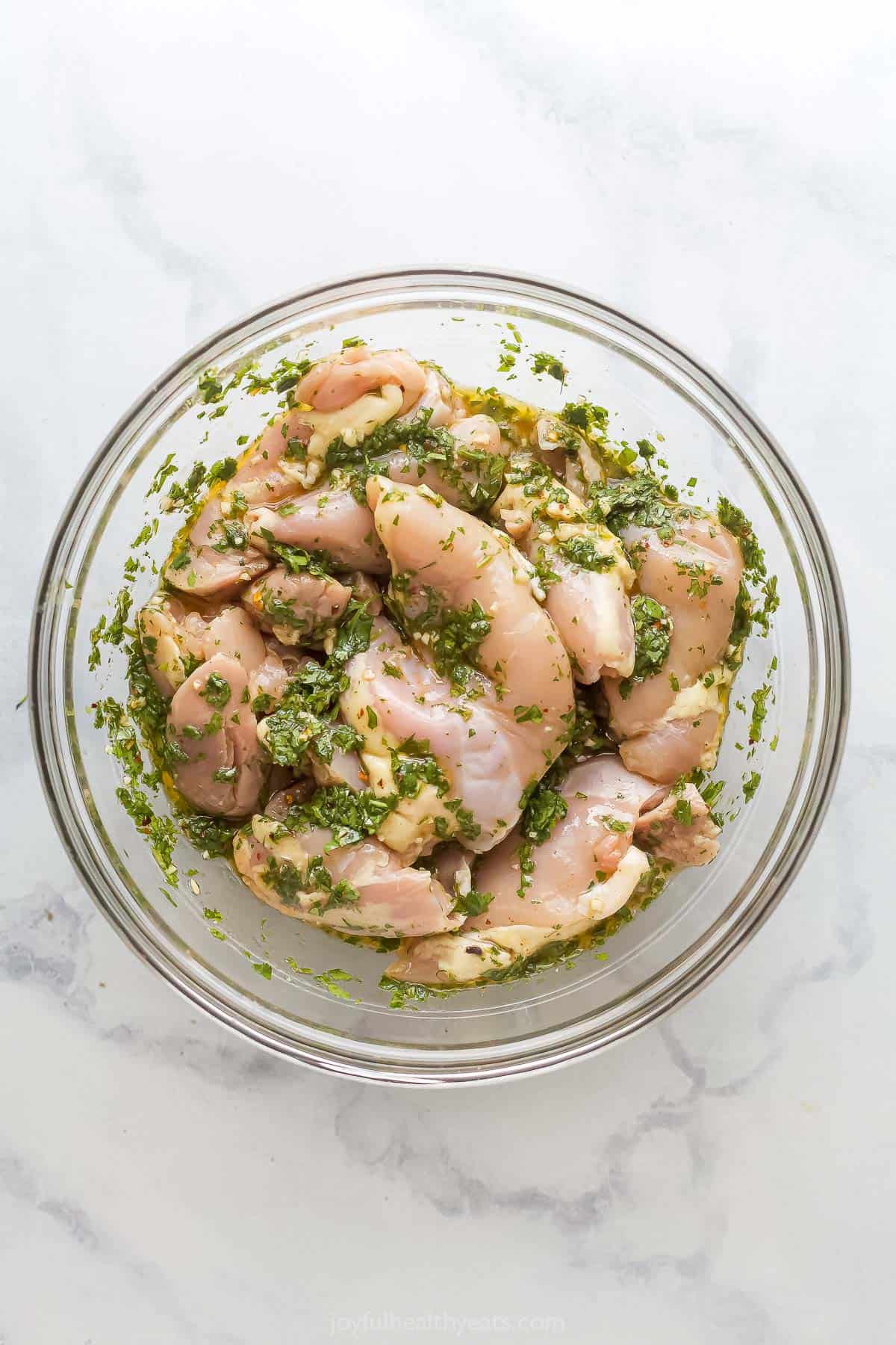 Marinating the chicken in a bowl. 