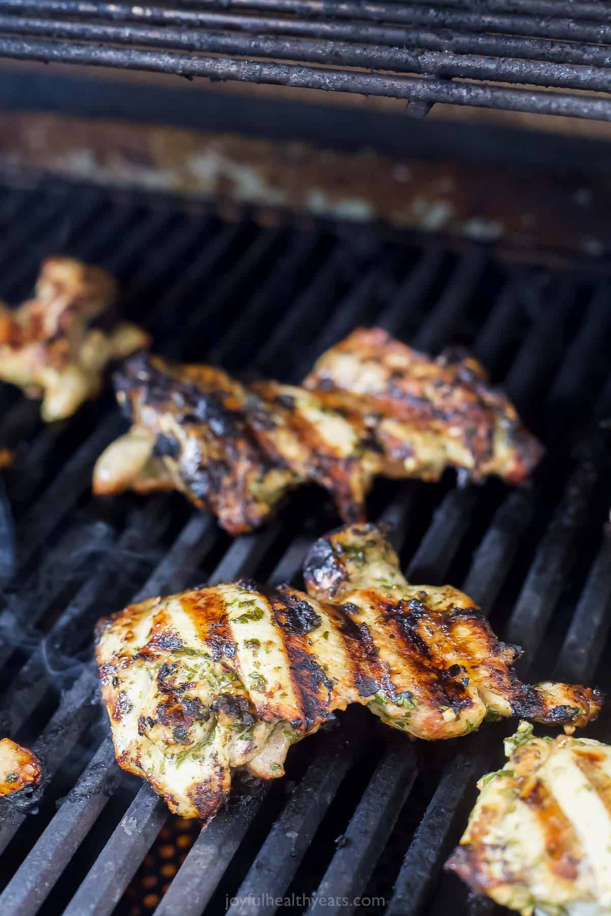 Topped with extra chimichurri, this juicy chimichurri chicken will be your new excuse to fire up the grill this summer. You'll love it! Grilling the chicken.