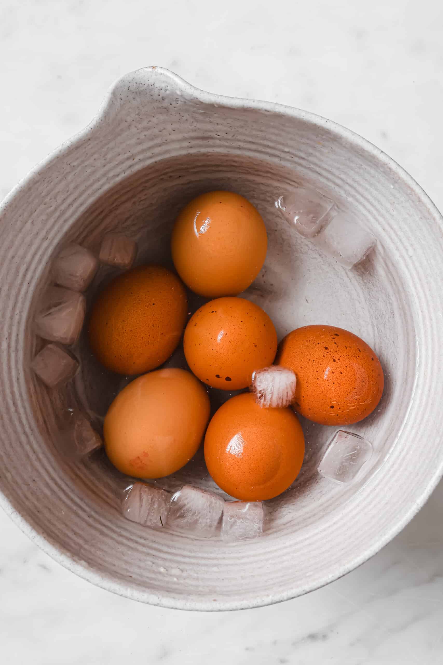 Placing the eggs in an ice bath.