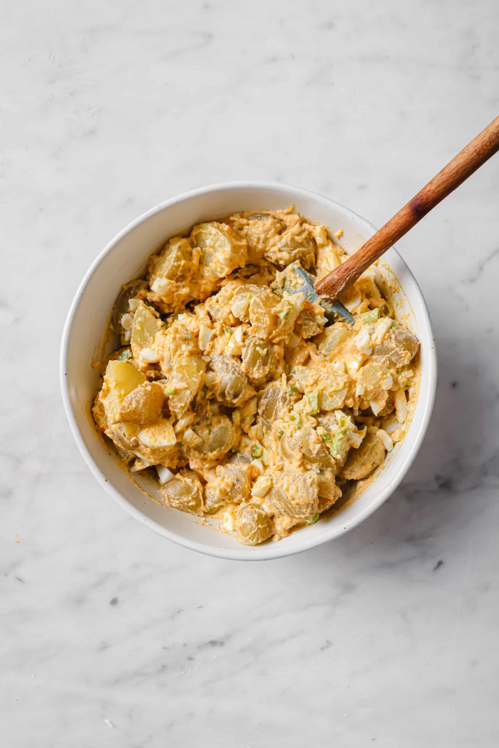 This easy deviled egg potato salad is creamy, tangy, and rich. Served chilled or warm, it'll be your new favorite summer side! Bowl of deviled egg potato salad.