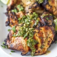 Close-up of grilled chicken with chimichurri on top.