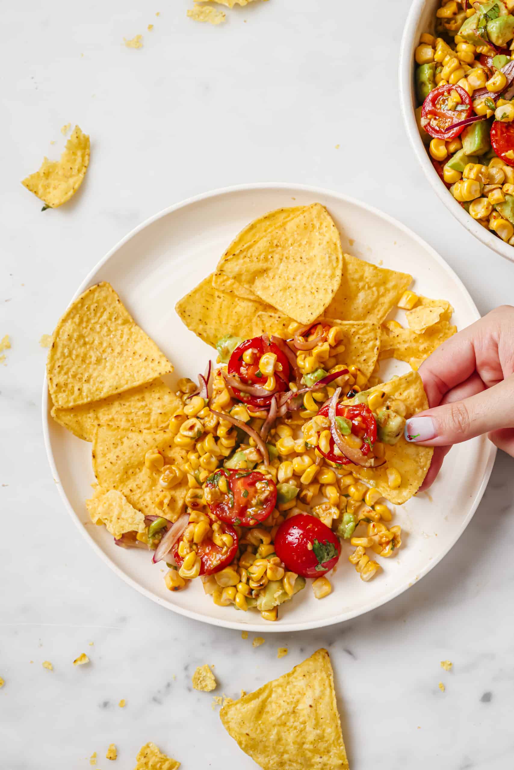 This easy avocado corn salad with a tangy honey dressing will find its way to your menu again and again. It's perfect! Dipping a tortilla chip into the avocado corn salad.