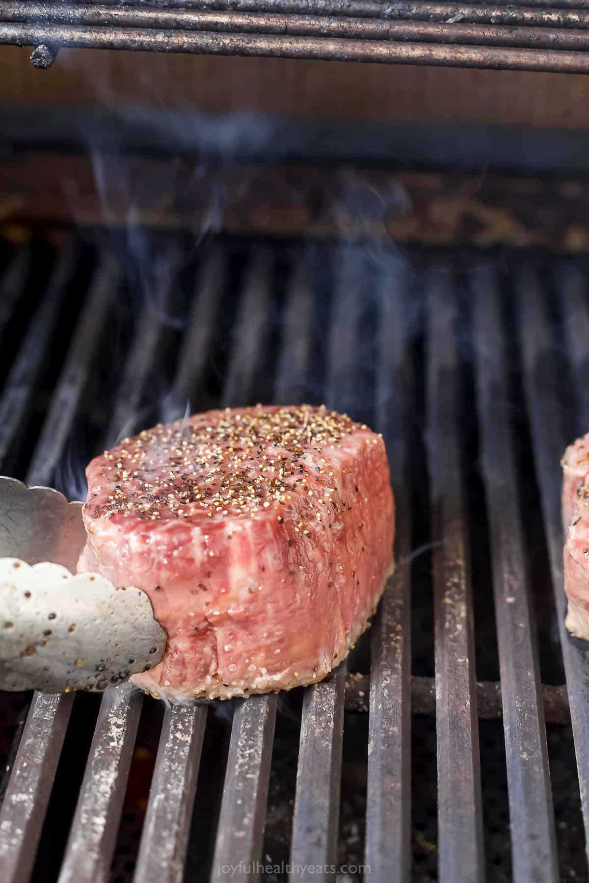 Placing the steaks on the hot grill. 