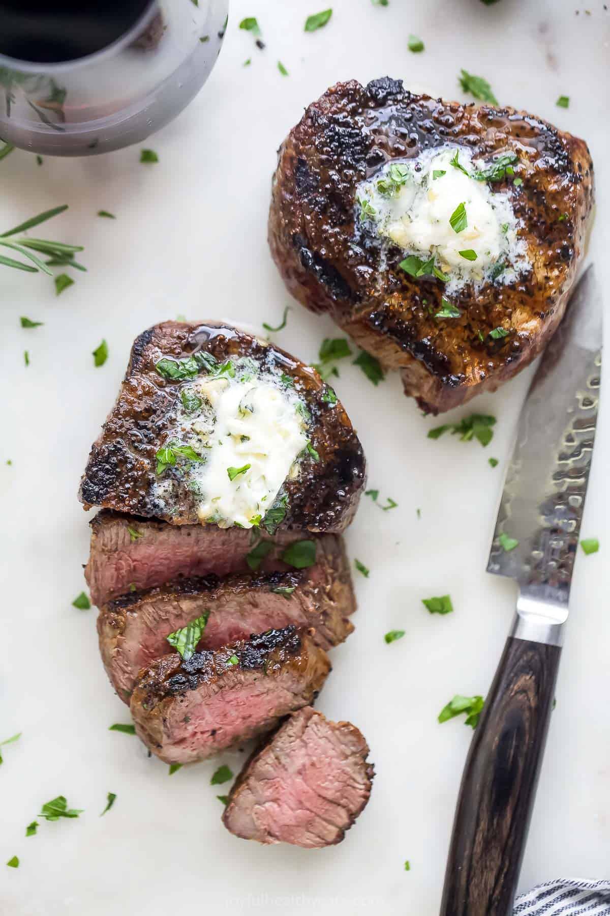 This 3-ingredient grilled filet mignon recipe is a juicy steak dinner you'll love for any weeknight or special occasions. Sliced grilled filet mignon with a pink center.