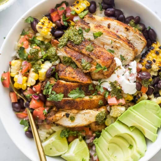 A chicken rice bowl with avocado and pico de gallo.