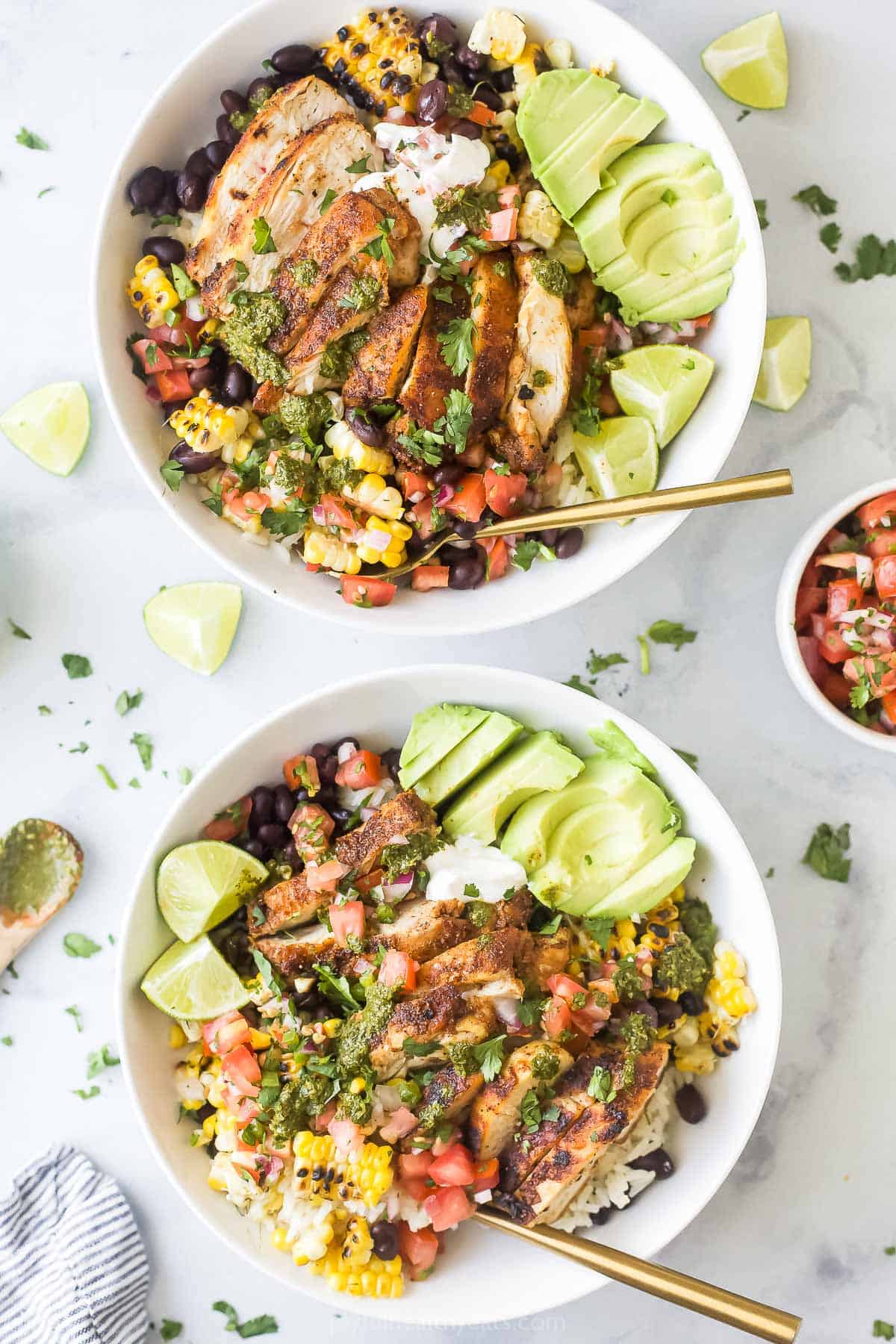 Two burrito bowls with toppings. 